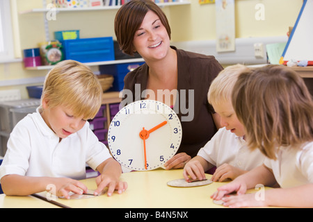 Schüler in der Klasse lernen, wie man die Zeit (Tiefenschärfe) zeigen Stockfoto