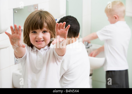 Studenten im Bad am Waschbecken waschen der Hände mit einem hochhalten seifigen Händen (Tiefenschärfe) Stockfoto