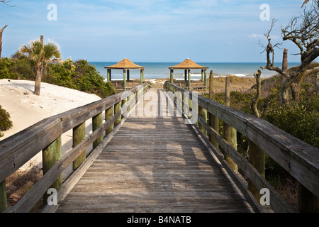 Lange Holzsteg führt um zu sand Strand und überdachte cabanas Stockfoto