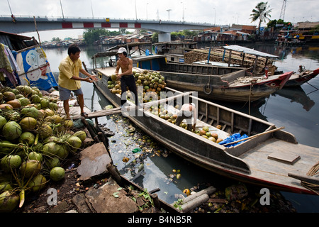 Männer entladen Boot voller Kokosnüsse bereit für den lokalen Markt Stockfoto