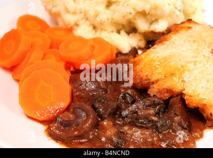 Seitenansicht einer Mahlzeit von Nieren- und Pilz Nierenfett Kruste Pie serviert mit Petersilienkartoffeln und Karotten Stockfoto