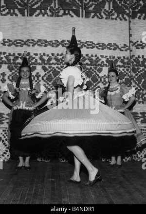 Tänzerin Elisabeth Varga gleicht ruhig ein Flagon Wein auf den Kopf, wie sie einen traditionellen ungarischen Volkstanz tanzt, die, den die Gruppe der Tänzer zur Teilnahme an einem Festival Folk-Songs und Musik bei London s Palace Theatre Juni 1956 sind Stockfoto