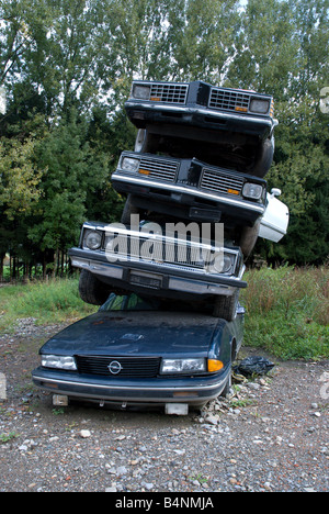 Schrottplatz: Einen alten Pontiac ist Bestandteil einer Sculphture gemacht zu schauen, wie ein Stapel von alten Polizeiautos Stockfoto