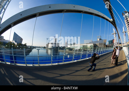 Junge Englisch Asiatische paar, fotografiert von einem Freund auf Millennium Bridge über den Manchester Ship Canal Lowry Kunstzentrum Stockfoto