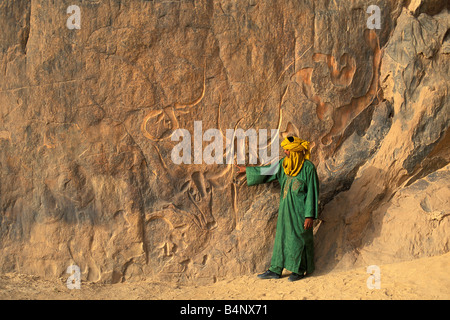 Algerien Djanet Mann der Tuareg Stamm vor prähistorischen Gravur die weinende Kuh Tassili n Ajjer Nationalpark UNESCO Stockfoto