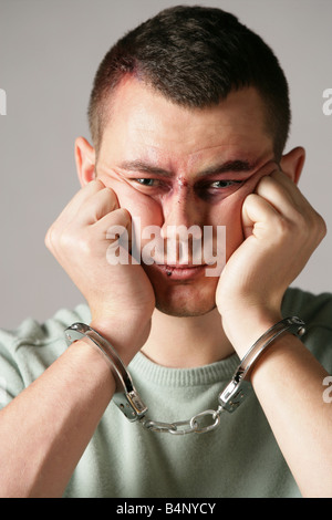 "Männermodel James mit einem gefälschten blauen Auge angewendet, indem make up Artist und tragen Handschellen" Stockfoto