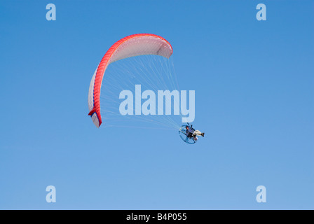 ein angetriebenes Paraglider auf der Flucht vor einem strahlend blauen Himmel Stockfoto