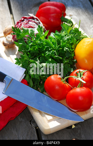 Verschiedene frische Gemüse auf Schneidebrett auf rustikalen Tisch Stockfoto