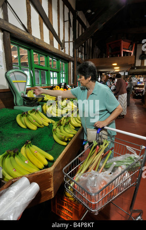 Einkaufen im Supermarkt Trolley interior Retail Farm Shop Geschäft Banane Obst Produkte auf dem Display Frau Überprüfung Gewicht auf Waage mit Essex Englan Stockfoto