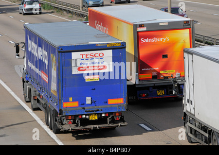 M25 Autobahn Sainsburys LKW überholen einen Tesco-LKW Stockfoto