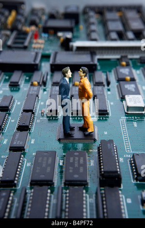 Figuren auf Männer stand über Motherboard und streiten Stockfoto