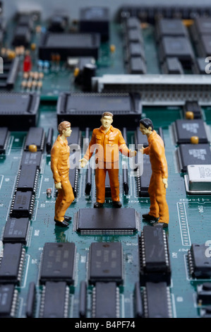 Figuren von Männern über Motherboard stehen und diskutieren Stockfoto