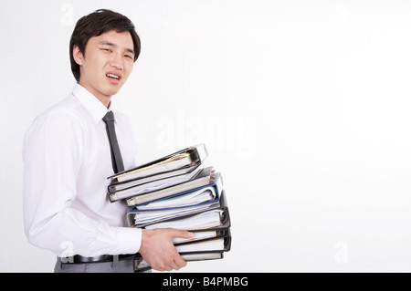 Geschäftsmann mit Stapeln von Dateien, Porträt Stockfoto