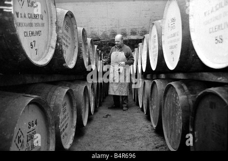 Angestellter der Knockando Whisky-Destillerie in Schottland prüft die Fässer im Zolllager der Whisky ein Minimum von drei Jahren, aber in der Regel zwischen 8 bleibt und 25 Jahre in Holzfässern reifen der Zolllager sind Cool und Erde Platt bieten eine gleichmäßige Temperatur und Luftfeuchtigkeit die Fässer verlieren etwa 2 Alkohol pro Jahr die so genannte Engel s-Aktie Januar 1972 Stockfoto