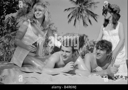 Komiker Schauspieler und Verleger Peter Cook mit seiner Frau Wendy rechts mit Dudley Moore und Suzy Kendall gesehen hier mit Sonnenöl eingerieben in ihren Rücken während eines Urlaubs in Grenada März 1966 Stockfoto