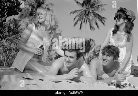 Komiker Schauspieler und Verleger Peter Cook mit seiner Frau Wendy rechts mit Dudley Moore und Suzy Kendall gesehen hier mit Sonnenöl eingerieben in ihren Rücken während eines Urlaubs in Grenada März 1966 Stockfoto