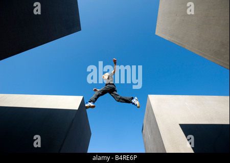 Junge, springen zwischen Betonklötzen am Denkmal für die ermordeten Juden Europas im zentralen Berlin Deutschland 2008 Stockfoto