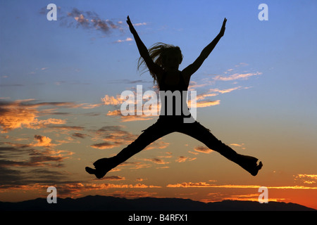 Silhouette einer springenden Frau bei Sonnenuntergang Stockfoto