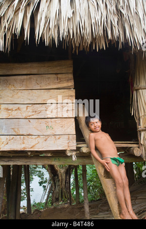 Panama, Chagres River Embera Dorf, Embara junge lehnt sich an traditionellen strohgedeckten Hütte Stockfoto