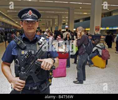 Ein bewaffneter Polizist patrouilliert Manchester Airport nach anti-Terror-Einheiten der Metropolitian Polizei und MI5 vereitelt ein Terroranschlags auf mehrere Flugzeuge im Flug zwischen den Vereinigten Staaten und das Vereinigte Königreich mit Sprengstoff in die Luft sprengen in der hand Gepäck August 2006 geschmuggelt Stockfoto