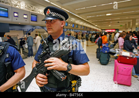 Ein bewaffneter Polizist patrouilliert Manchester Airport nach anti-Terror-Einheiten der Metropolitian Polizei und MI5 vereitelt ein Terroranschlags auf mehrere Flugzeuge im Flug zwischen den Vereinigten Staaten und das Vereinigte Königreich mit Sprengstoff in die Luft sprengen in der hand Gepäck August 2006 geschmuggelt Stockfoto