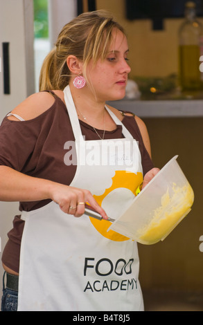 Junge Frau, die kochen in einem Wettbewerb in Abergavenny Food Festival, South Wales, UK Stockfoto