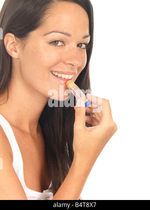 Junge Frau Anwendung Lippenbalsam zu trockene Lippen Isoliert gegen einen weißen Hintergrund mit einen Freistellungspfad Stockfoto