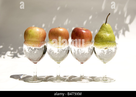 Weingläser mit Wasser und verschiedene Früchte in hellem Licht Stockfoto