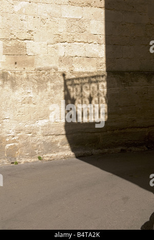 Schatten der reich verzierten schmiedeeisernen Balkongeländer fällt über alte Sandstein Gebäude in Montpellier, Frankreich Stockfoto