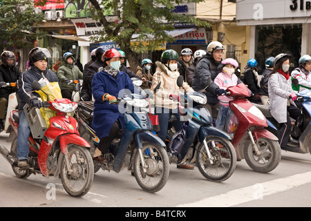 Motorradfahrer mit Facemark und Helm an der Kreuzung in Hanoi, Vietnam Stockfoto