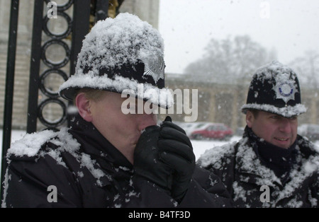 Schnee fällt in London nach langer Zeit Januar 2003 Polizisten versuchen, in den Schnee draußen Buckingham Palace Mirrorpix warm zu halten Stockfoto