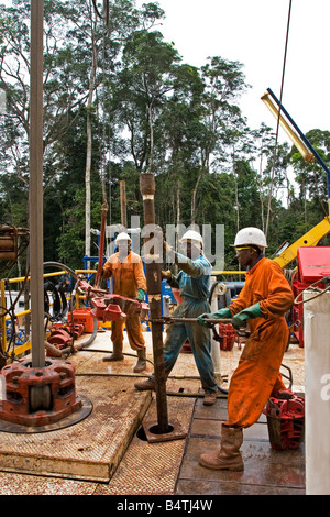 Abgelegenen Dschungel Regenwald onshore Öl- und Gasindustrie rig Website mit Arbeiter heben-Sub-Stecker für Rohr mit Kette Tong, Gabun, Afrika Stockfoto