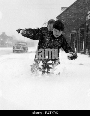 Wetter Schnee kalt Kinder jungen Pelze Holz in Kent, wo die Schneewehen vier Fuß tief diese beiden Jugendlichen erreicht, fand es schwer, durch den Schnee zu Fuß, während sie draußen spielen und Schneeballschlachten waren Stockfoto