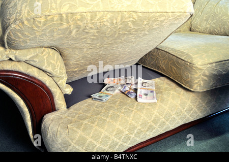Bündel von Pfund Sterling Bargeld in Banknoten Einsparungen gespeichert Im geheimen Versteck versteckt unter Sofa Sofa versteckt Stuhlkissen England GB Stockfoto