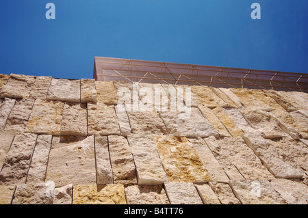 Teile der Basis Steinmauer und der oberen Glaskubus der Hauptsynagoge Ohel Jakob in München unter blauem Himmel. Stockfoto