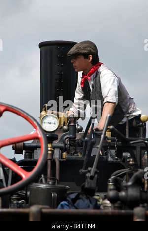 Ein Junge Enthusiasten in Tracht Verwatungsbereich ein Dampftraktor bei einer Oldtimer-Show. UK Stockfoto