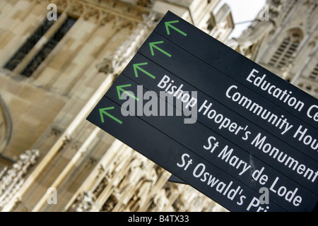 Stadt von Gloucester, England. Abgewinkelt, nahe Ansicht von einem Besucher Richtung Wegweiser mit Gloucester Kathedrale im Hintergrund. Stockfoto