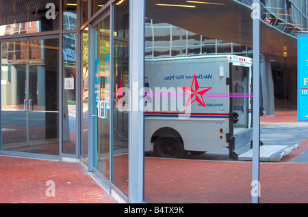 Reflexion eines US-Post-LKW in einem Fenster eines Bürogebäudes Stockfoto