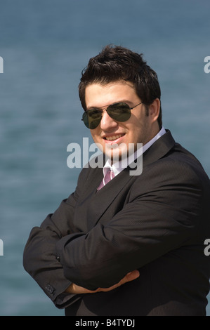 Happy Business Mann Arme verschränkt am Meer Stockfoto