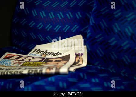 Die London Papier und London Lite Zeitungen entschied auf Zug Sitz Stockfoto