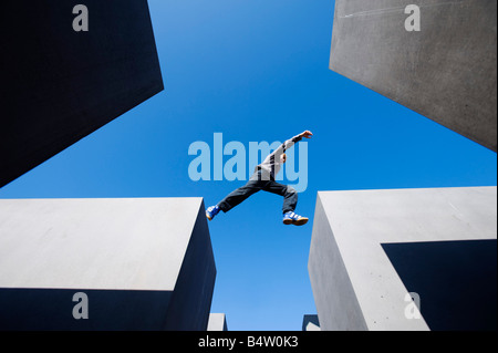 Junge, springen zwischen Betonklötzen am Denkmal für die ermordeten Juden Europas im zentralen Berlin Deutschland 2008 Stockfoto