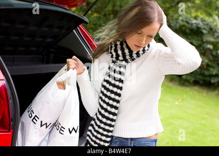 Mädchen auf der Suche deprimiert mit Einkaufstüten Stockfoto