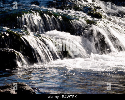 Schnell fließendes Wasser kommen über Felsen zu einen kleinen Wasserfall bilden Stockfoto