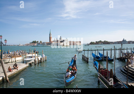 Personen, die eine Gondel Fahrt mit der Basilika San Giorgio Maggiore über die Lagune im Hintergrund Stockfoto