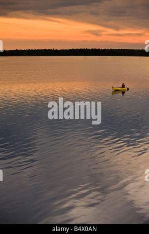 Kanufahren auf Lake Audy bei Sonnenuntergang im Riding-Mountain-Nationalpark, Manitoba, Kanada. Stockfoto