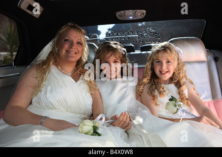 Braut und Brautjungfern, die Ankunft in einer rosa gestreckten Limousine für die Trauung Stockfoto