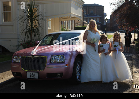 Braut und Brautjungfern, die Ankunft in einer rosa gestreckten Limousine für die Trauung in der Kommissar Haus in Chatham Dockyard Stockfoto