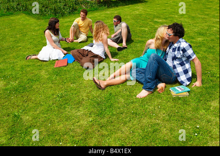 Gruppe von Jugendlichen auf Rasen sitzen Stockfoto