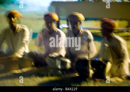 Indischer Musiker spielen bei Sonnenuntergang auf dem Rasen, das Pugmark Hotel, Rajasthan, Indien Stockfoto