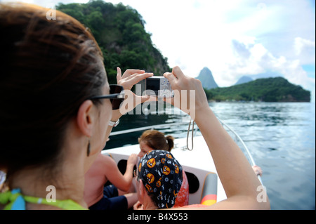 EIN TOURIST AUF EINE BOOTSFAHRT IN DER NÄHE VON SOUFRIÈRE ST LUCIA FOTOGRAFIERT DIE ANSICHT MIT DEN BERGEN PETIT LINKS UND GROS PITON AUF DEN HORIZO Stockfoto